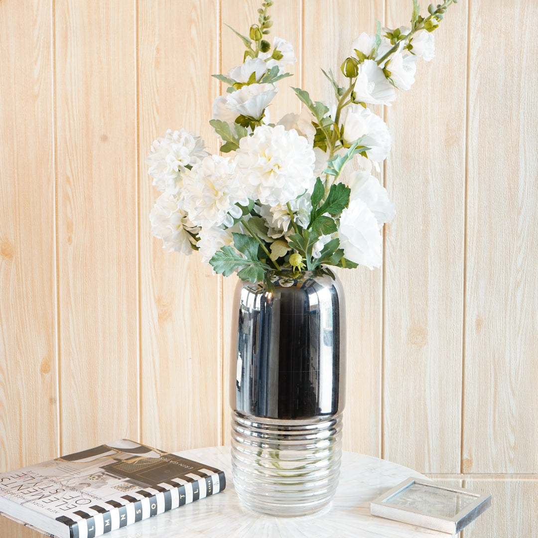 Silver gradient fluted glass flower vase with white flowers on a side table