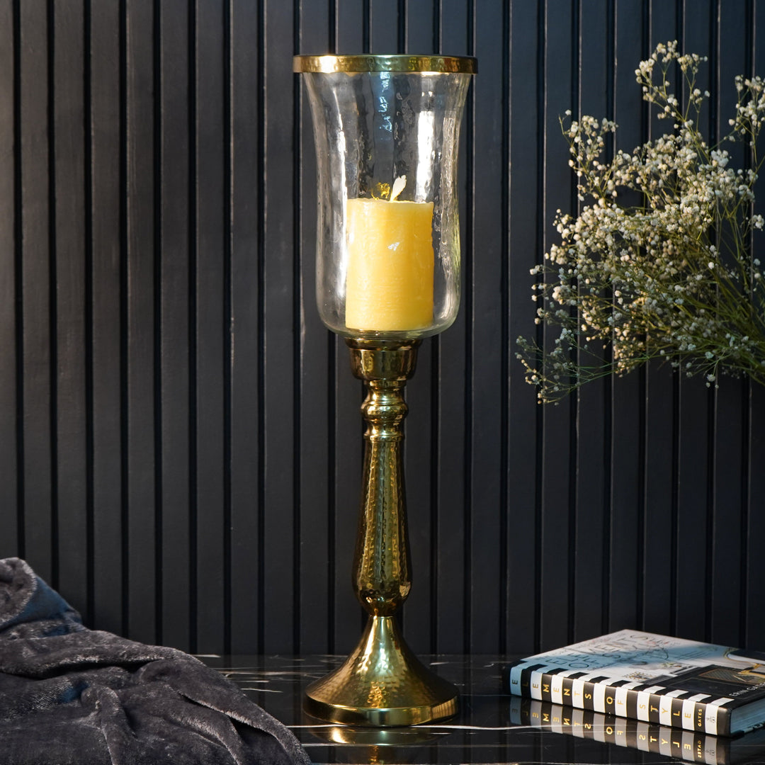 Gold hammered vintage candle holder with glass shade and a lit pillar candle