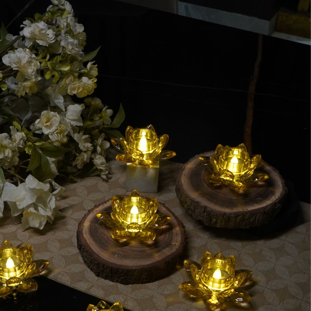 Gold LED lotus tealights glowing on wooden slices for a Diwali table